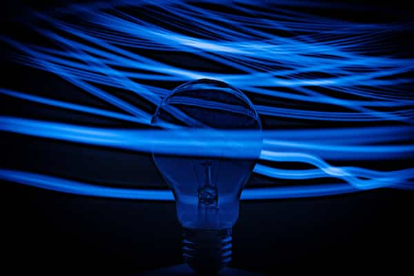 Light bulb with blue light waves on a dark background