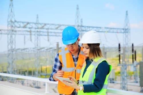 2 utility workers converse over tablet data